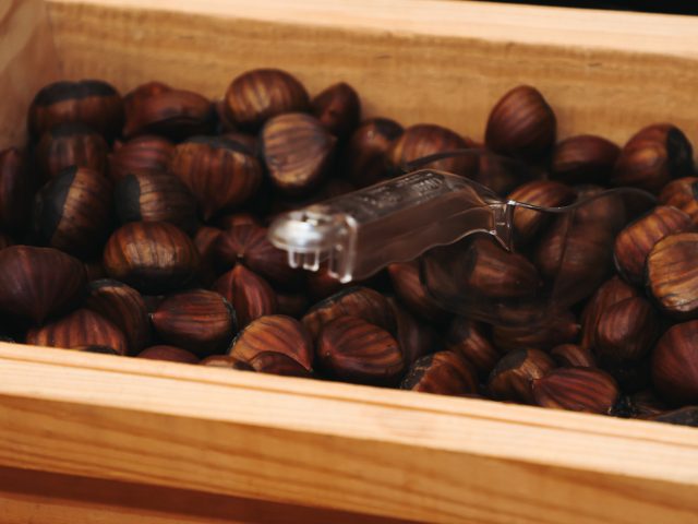 wooden crate filled with roasted chestnuts